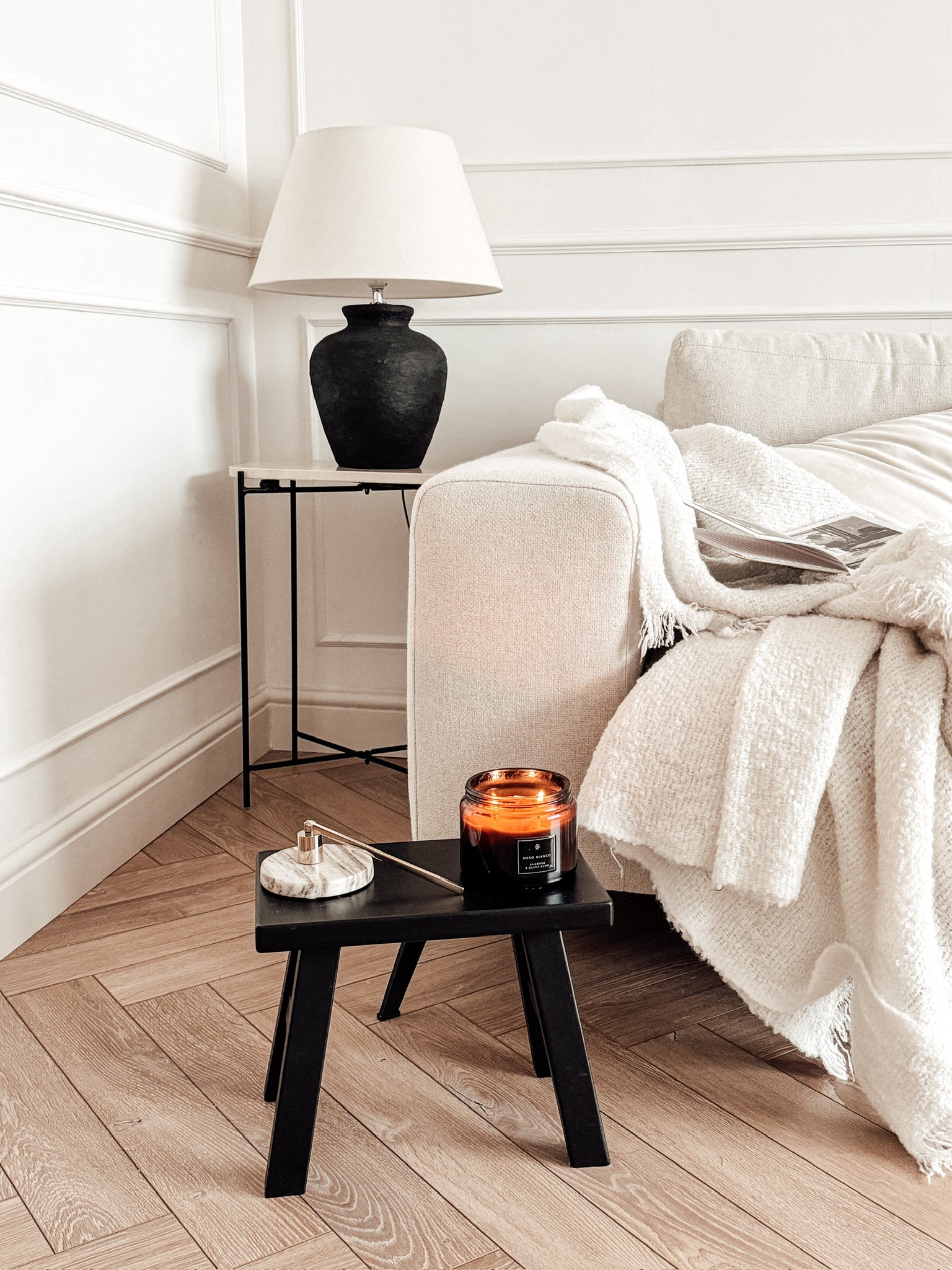Cozy living room with a sofa, side table, and amber dual wick candle