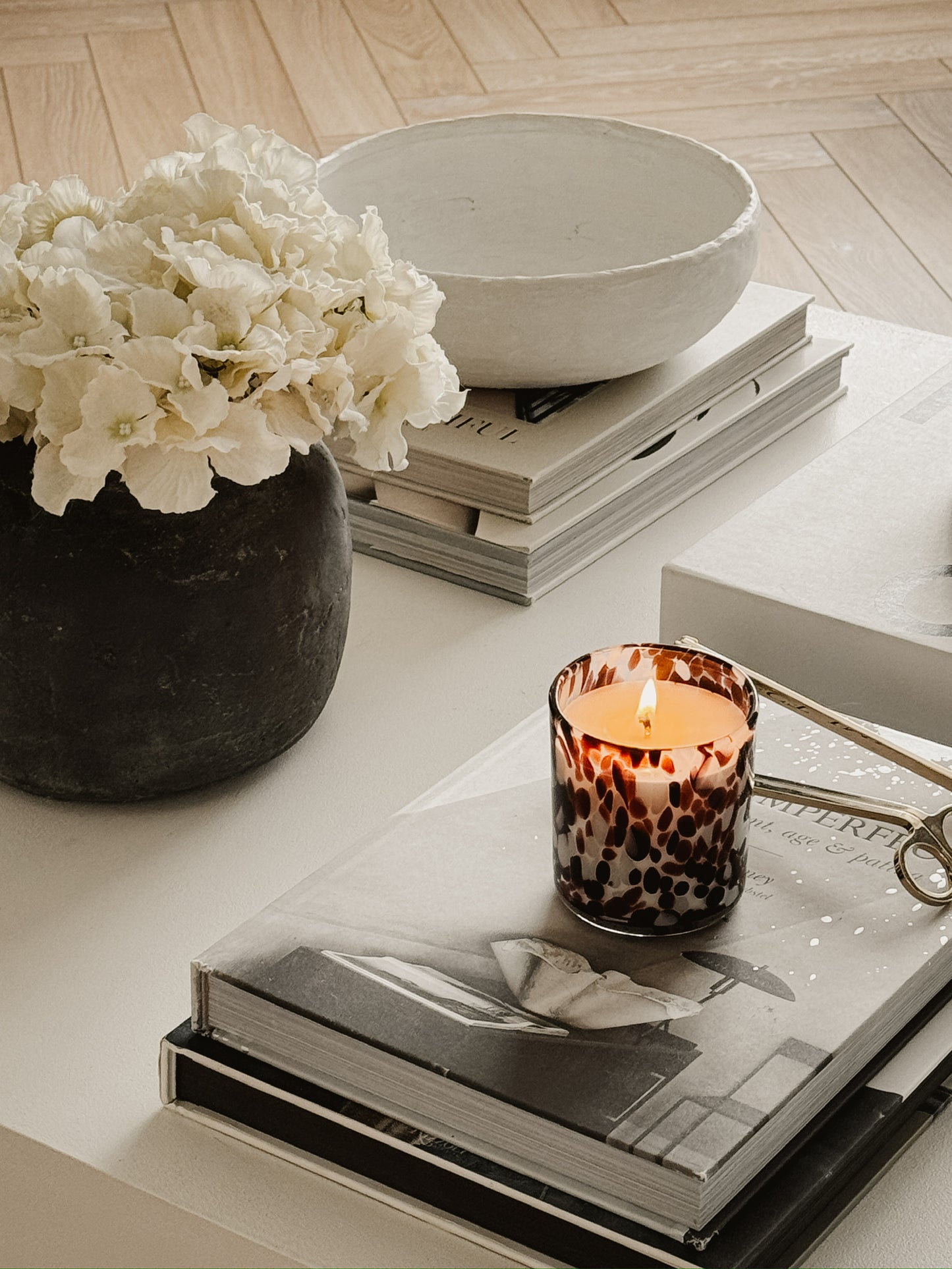 burgundy and white cheetah print candle on a coffee table styles with flowers and books