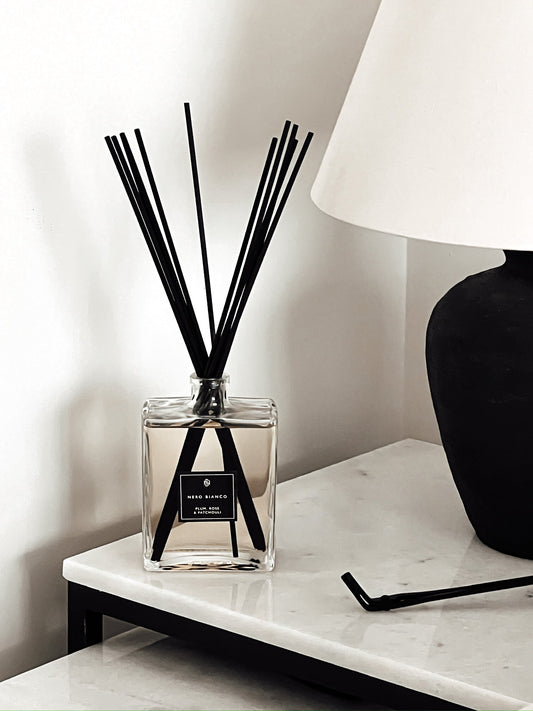 Large Reed Diffuser in rectangle glass bottle styled on a marble table in scent plum, rose and patchouli