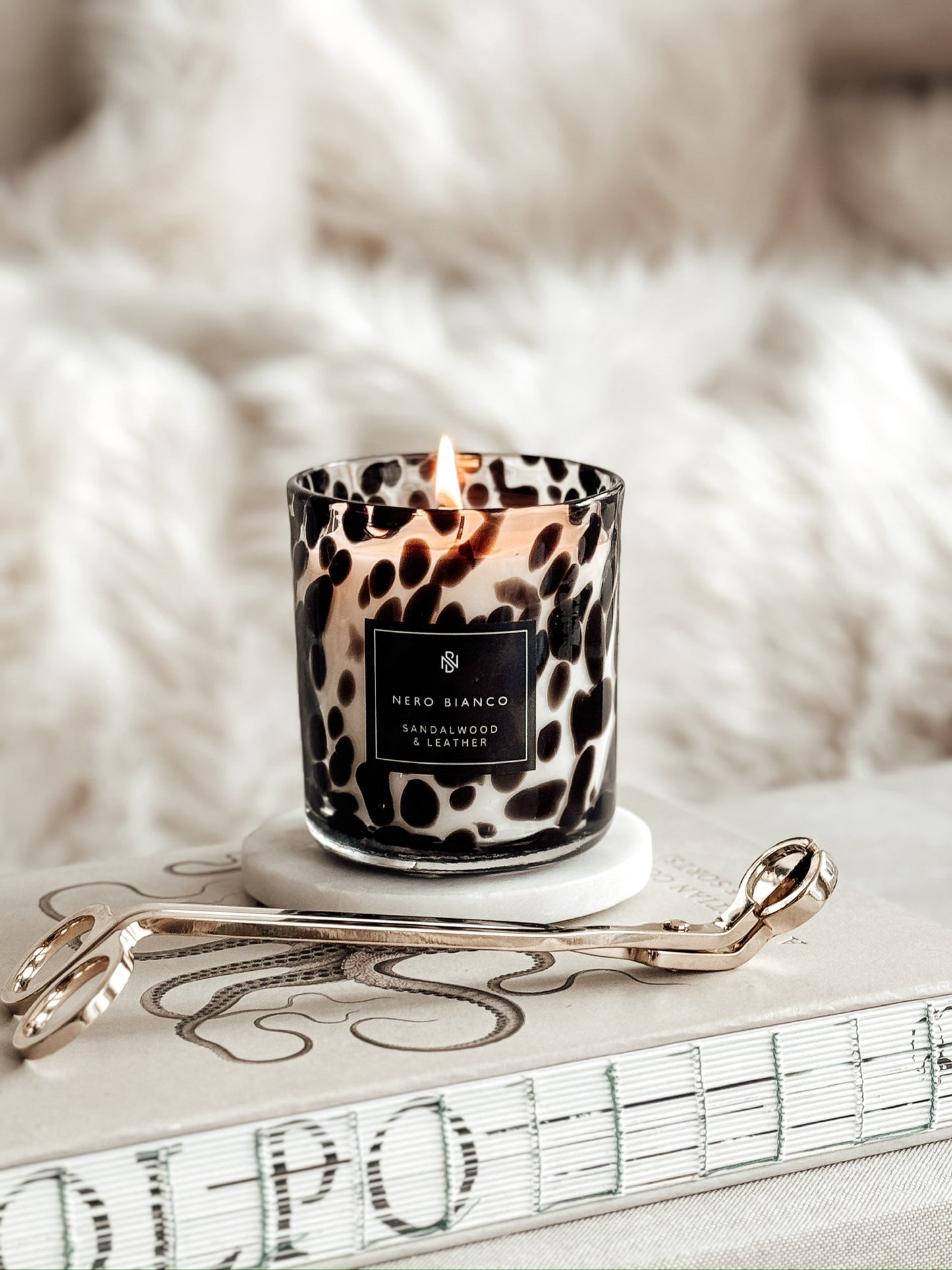 cheetah print candle with gold wick snippers styled on a book