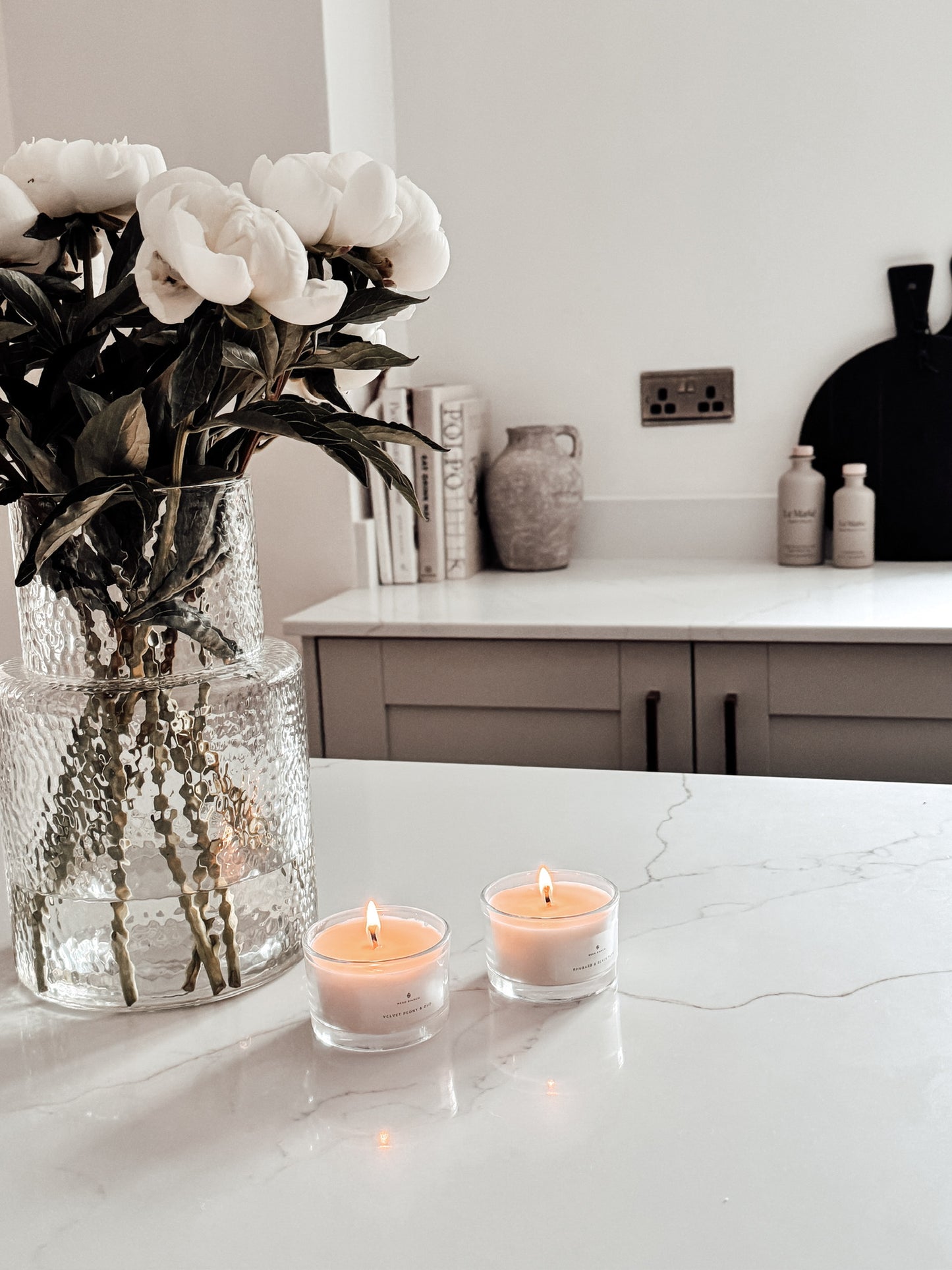 Votive Candles in a neutral kitchen with black accents and vase of peonies