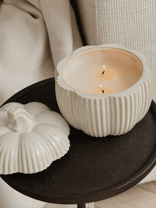 RIBBED PUMPKIN CANDLE WITH LID ON A BLACK TABLE