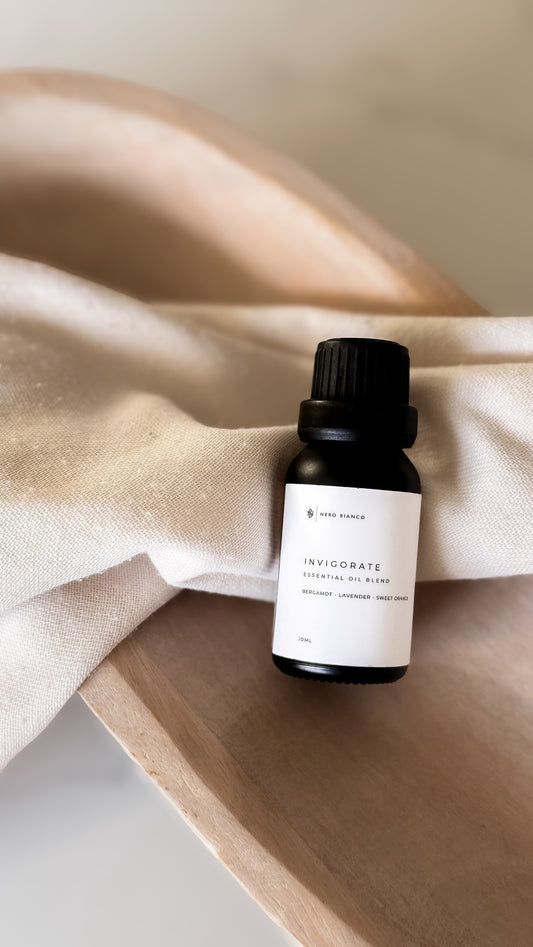 Small black bottle with a white label on a beige fabric background