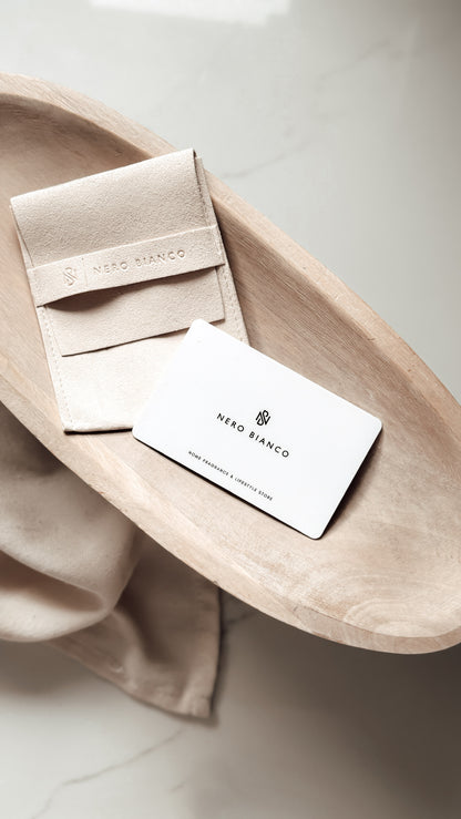 Nero Bianco gift voucher card and pouch on a wooden surface