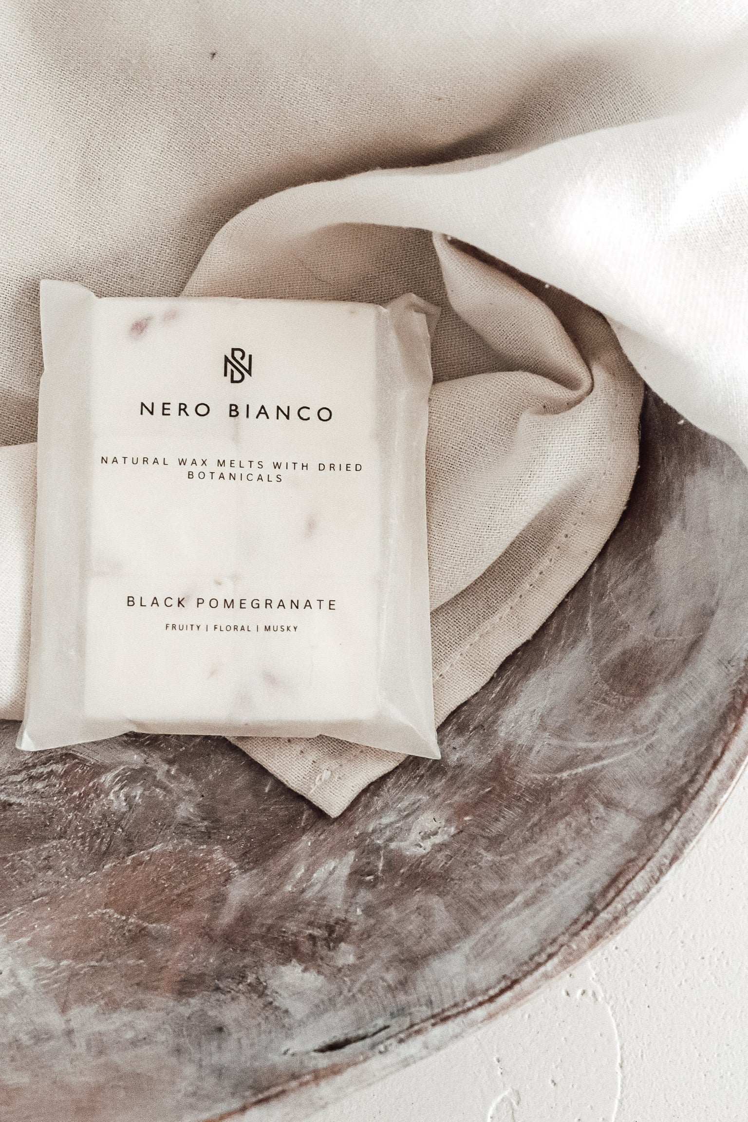 Nero Bianco soy wax melts styled on a neutral plate