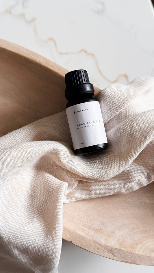 Small black and white bottle on a textured beige surface