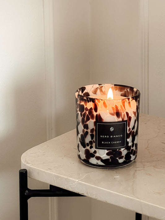 black cherry burgundy cheetah candle on a marble side table
