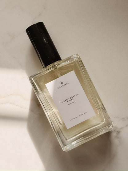 cuban tobacco and oak room spray in rectangle bottle with a black cap on a marble surface