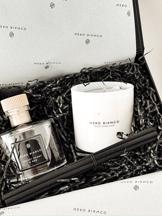 Gift set with a candle, diffuser, and packaging labeled 'Nero Bianco' on a neutral background.