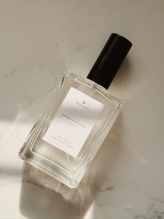 room spray in rectangle bottle with a black cap on a marble surface