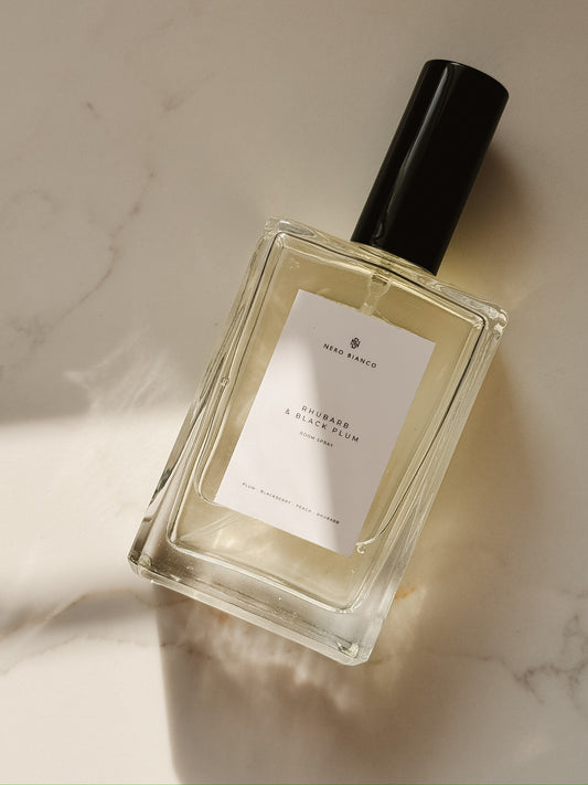 rhubarb and black plum room spray in rectangle glass bottle with a black cap on a marble surface