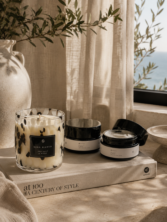 Candle and hand lotion on a surface with a scenic background