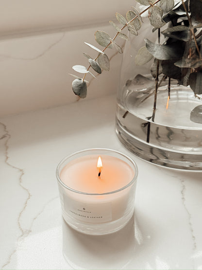 Votive Candle Sandalwood & Leather scented on neutral worktop with eucalyptus
