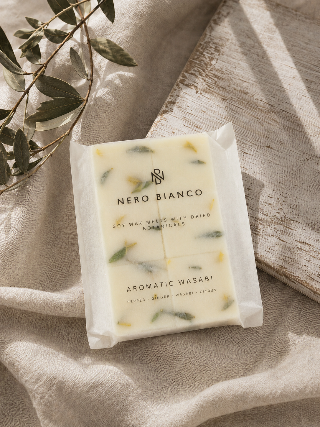 a pack of six soy wax melts laying on a beige cloth with olive branches
