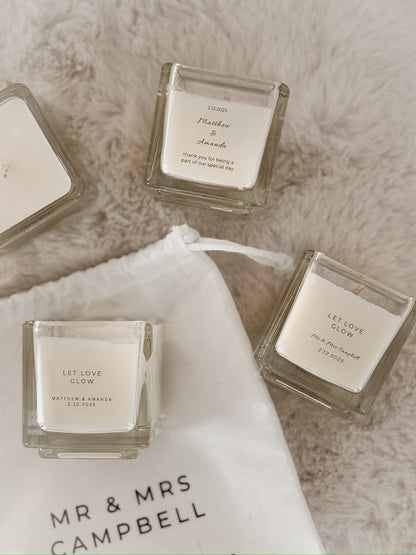 Four square candles with customised labels on for wedding favours