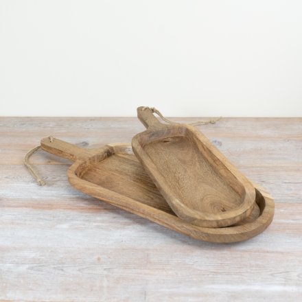 Two wooden serving tapas board trays with handles on a light wooden surface
